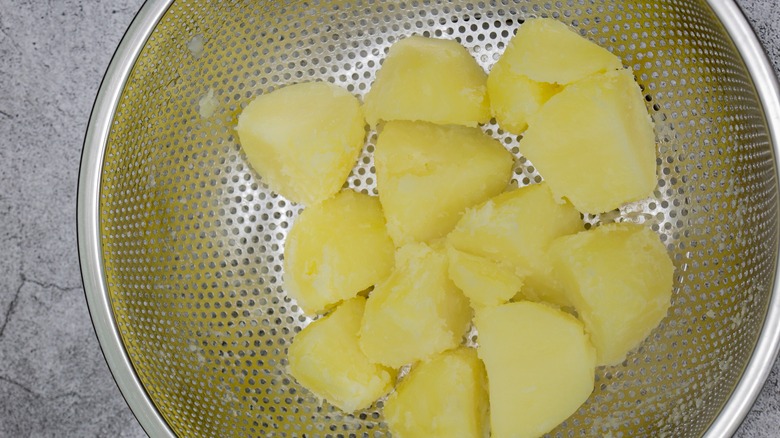 Cooked potatoes drying out in colander