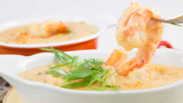 Shrimp and grits are shown in a white bowl.