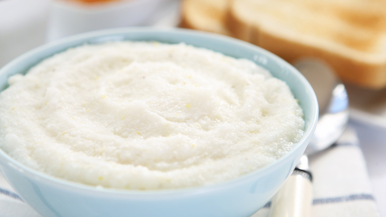 A blue bowl is filled with plain grits.