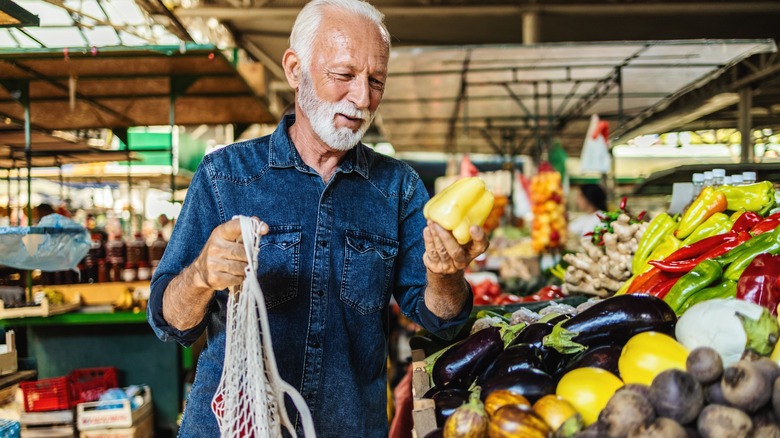 Man holding bell pepper at market