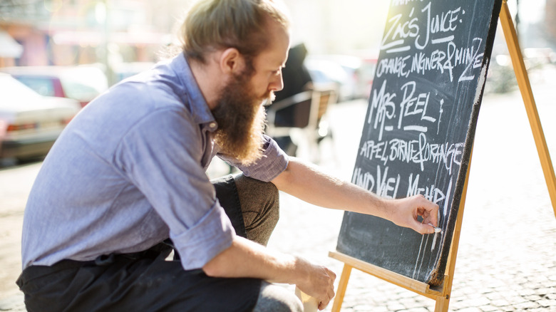 Restaurant worker writing menu