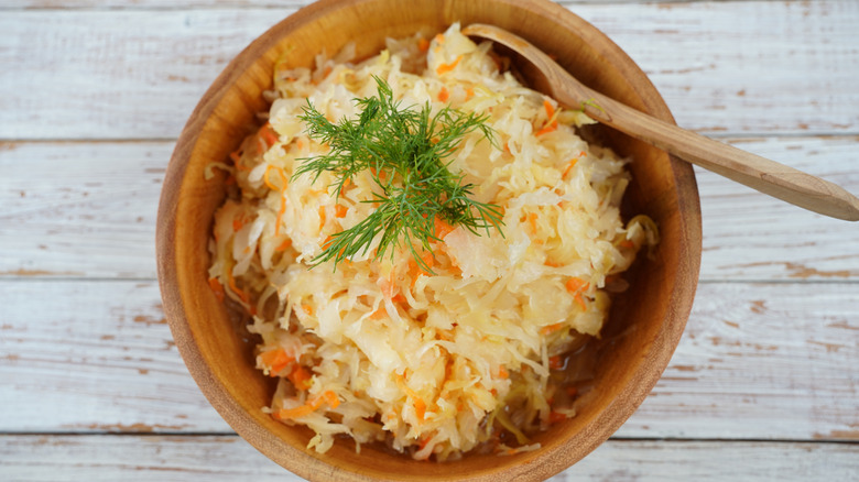 bowl of sauerkraut with wooden spoon