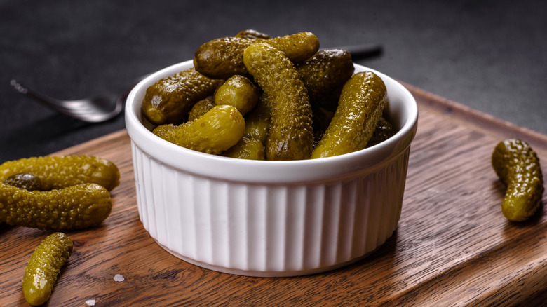 bowl of cornichon on wooden board