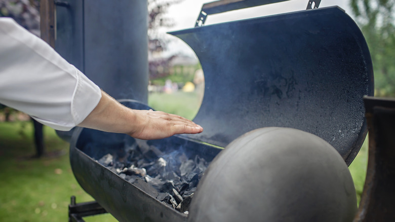 Man using barrel grill