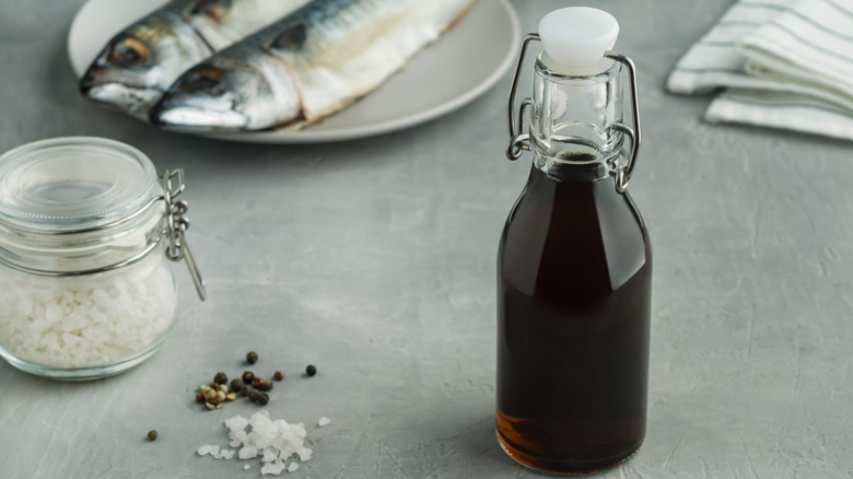 Bottle of fish sauce with fish and salt