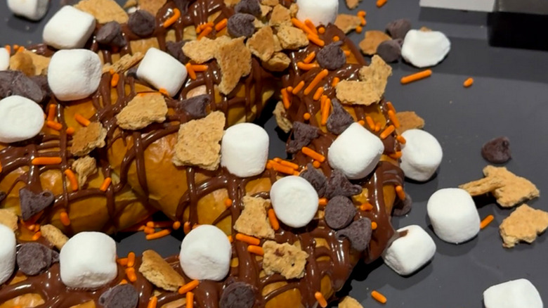 Large pretzel covered with chocolate drizzle, mini marshmallows, chocolate chips, and graham cracker pieces