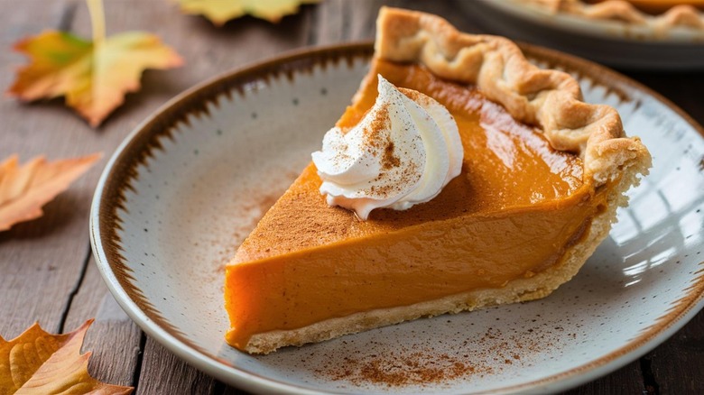 Slice of pumpkin pie with whipped cream on top