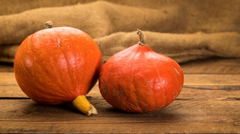 Red Kuri pumpkins on a wooden table