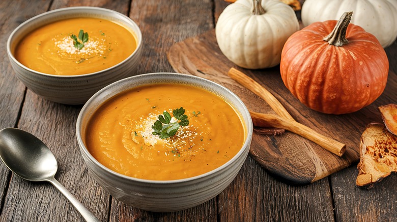 Bowls of pumpkin soup on a wooden table