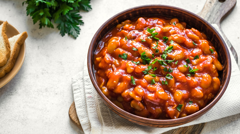 Baked beans in their sauce with meat and spices in brown bowl