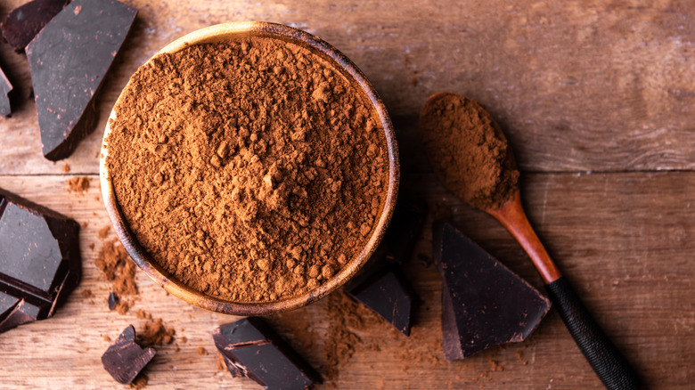 cocoa powder with dark chocolate against wooden background