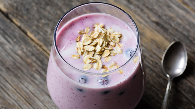 raw oats garnishing a blueberry protein shake