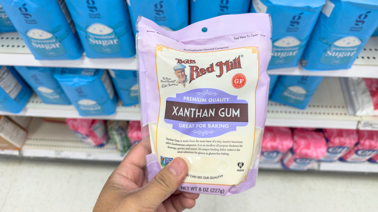 hand holding a bag of Bob's Red Mill Xanthan Gum in a supermarket