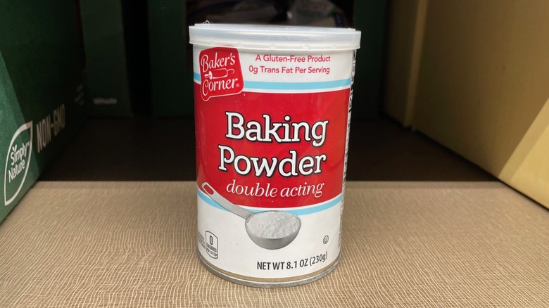 A canister of Aldi baking powder sits on the store shelf.