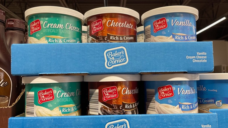 Cans of Aldi frosting are in a display box at the store.