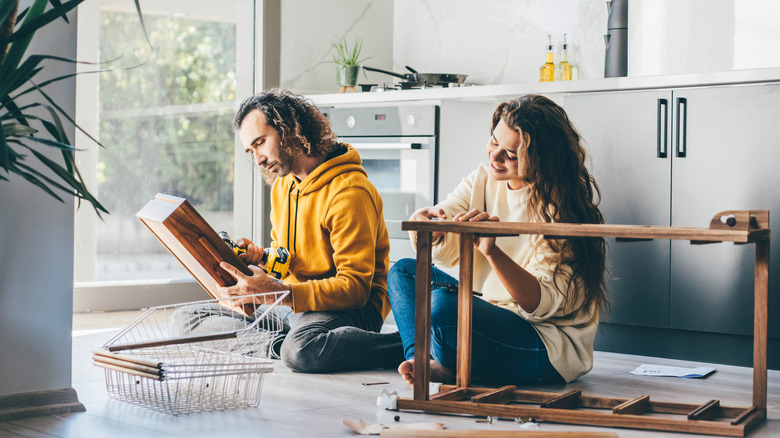Couple assembling kitchen furniture