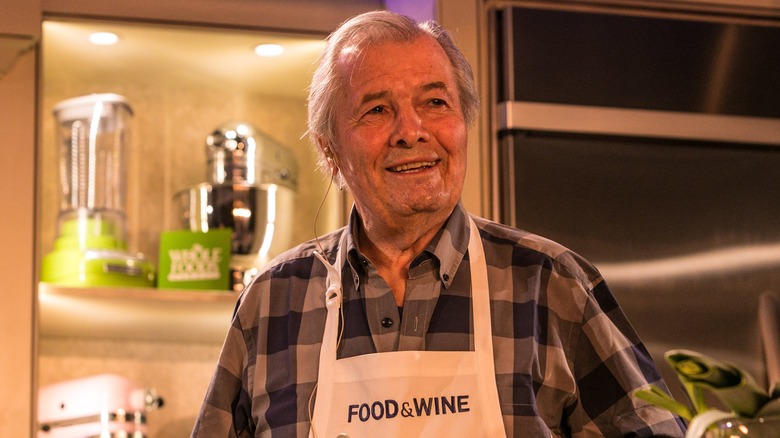 Jacques Pepín wearing a Food & Wine apron in a kitchen