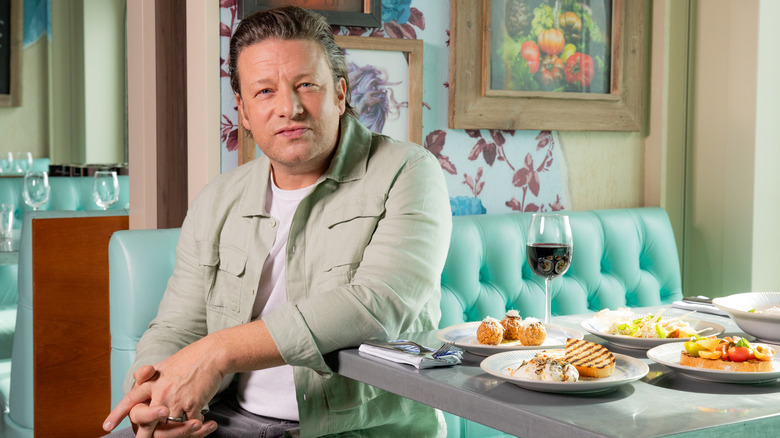 Jamie Oliver in a booth with brunch dishes