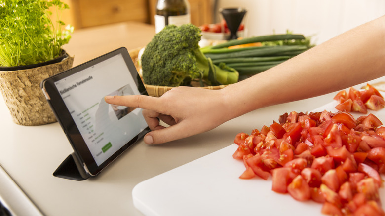 a hand scrolling a screen's online recipe