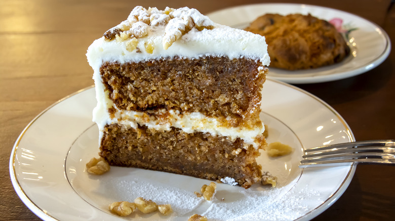 carrot cake topped with vanilla frosting and praline nuts