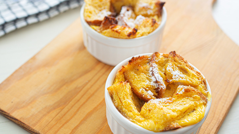 Small dishes of baked bread pudding on board