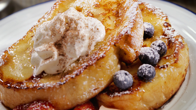 French toast with syrup, whipped cream, and berries