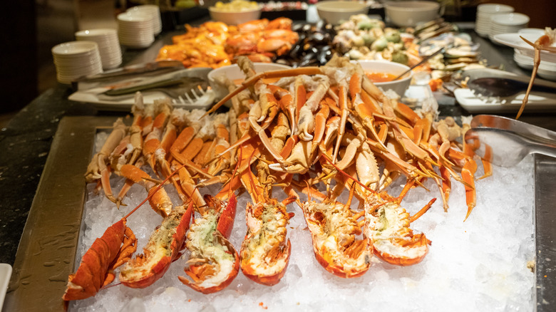 pile of lobster and crab legs on ice at buffet