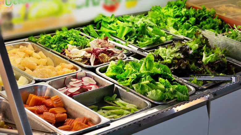 salad bar with leafy greens and various vegetables