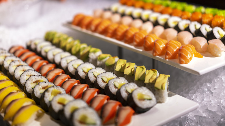 various rolls of sushi on white display trays