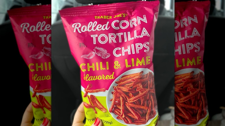 Woman holding bag of Trader Joe's chili & lime chips