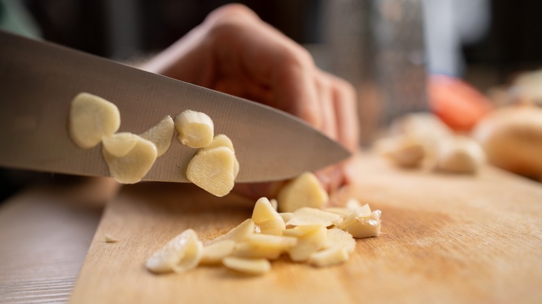 Person chopping fresh garlic