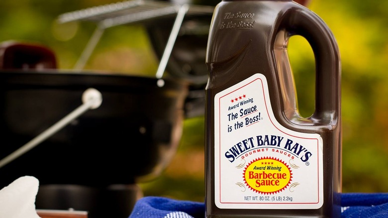 Bulk-sized jug of Sweet Baby Ray's Barbecue Sauce on outdoor table