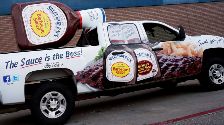 Truck with oversized bottle of Sweet Baby Ray's BBQ Sauce in the bed