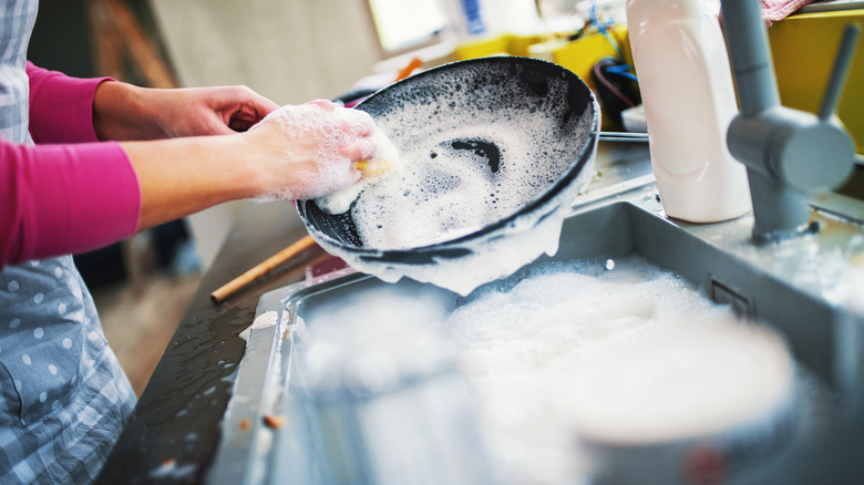 Woman washing cooking pan