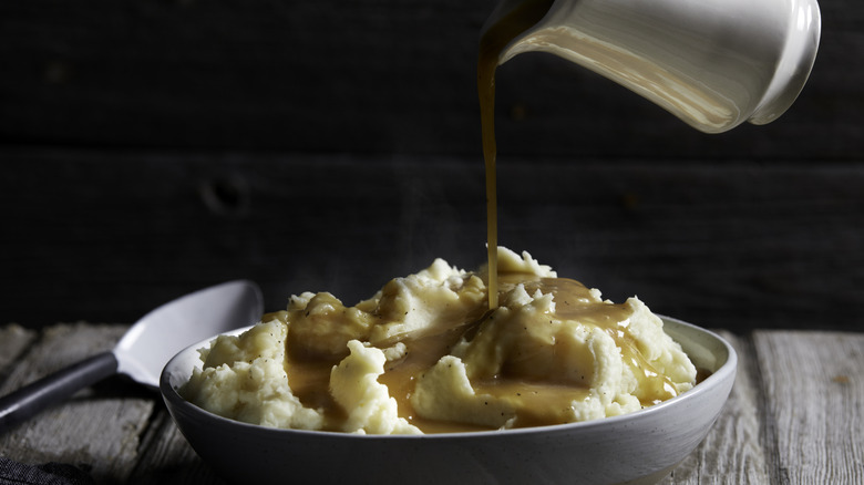 Gravy pouring onto mashed potatoes