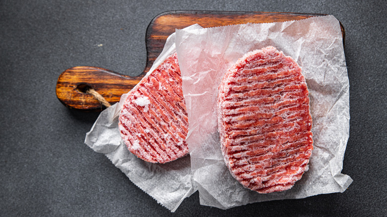 frozen burger patties on cutting board