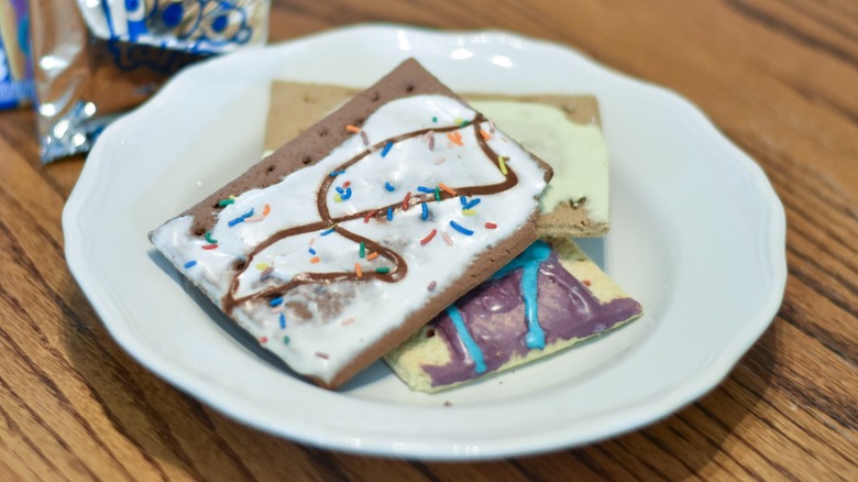 A white plate with Pop Tart stacked on it on a wooden table