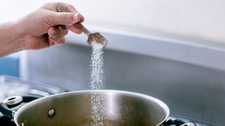 Sprinkling salt into boiling water