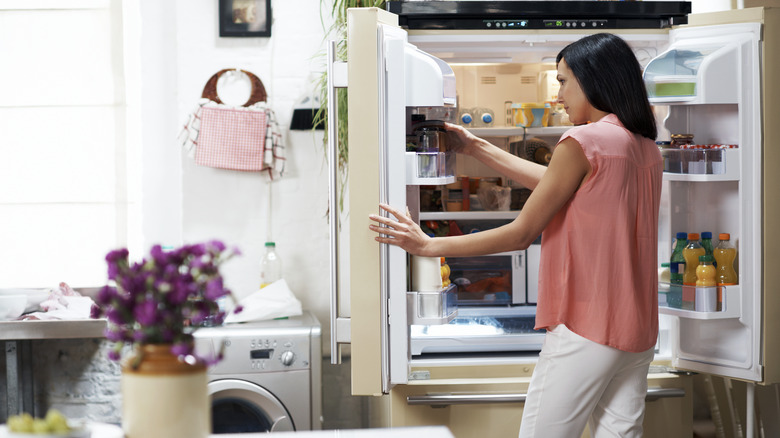 woman looking inside fridge