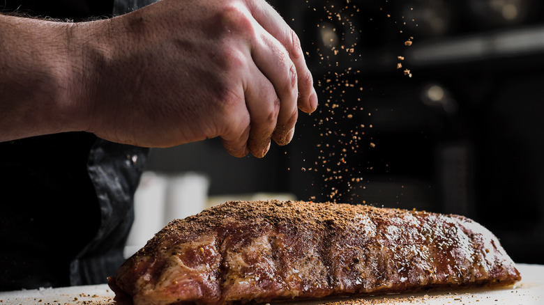 Person seasoning a steak