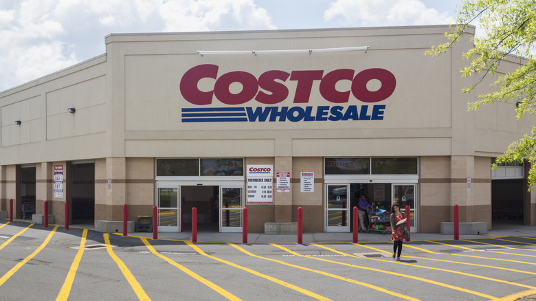 A woman walks out of Costco Wholesale toward the parking lot