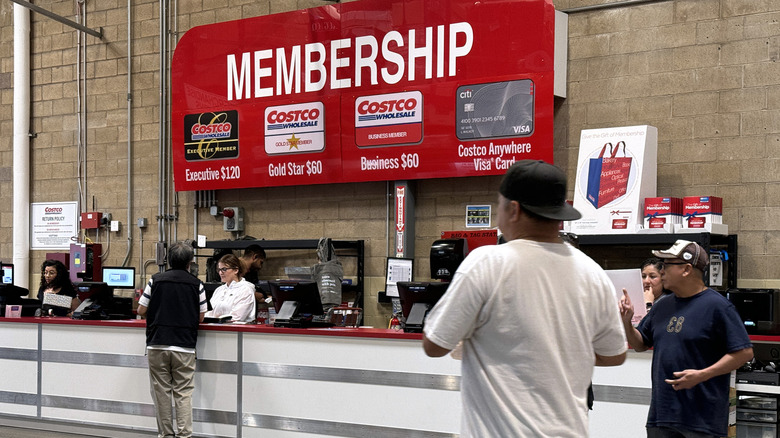 Customers walk by the Costco membership counter at the store