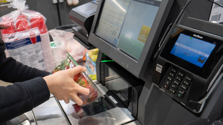 A person scanning a box of strawberries at the Costco register