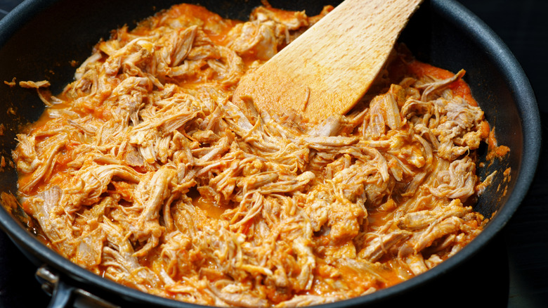 Pulled pork in a frying pan with braising liquid