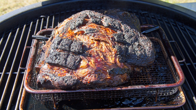 A smoked pork shoulder on a grill