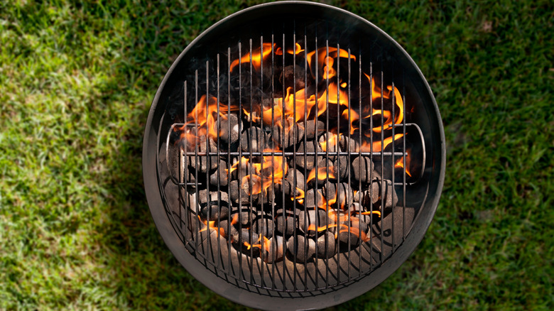 lit charcoal grill on grass