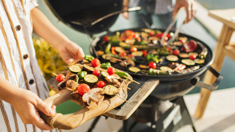 person carrying veggie skewers