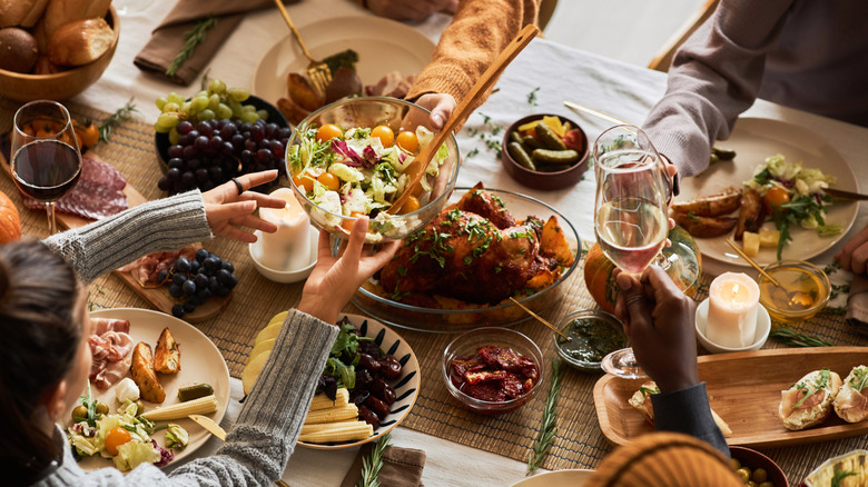 group of people at the dinner table passing food around