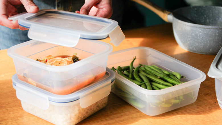 hands placing leftovers into 3 containers