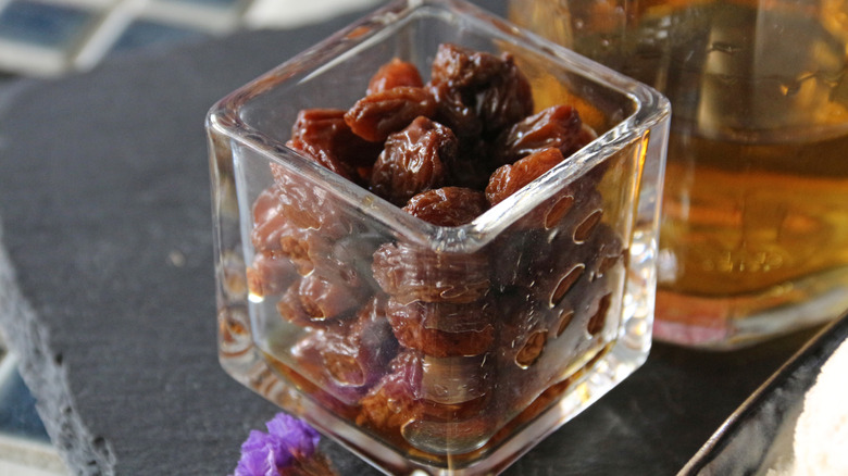 dried raisins soaking in rum in a glass bowl